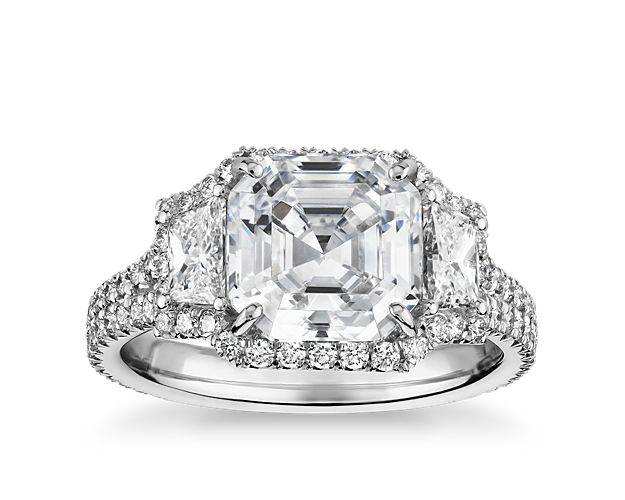 Showcase the breathtaking Asscher-cut diamond of your choice in this shining platinum engagement ring, flanked with dazzling trapezoid diamonds and enlivened with a brilliant pavé halo.. For center stones 1.5  to 3 carats. Stock number 68095 supports centers down to 0.5 carats.