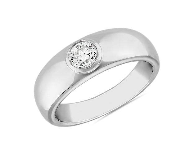 Flawless style you can hold onto forever defines this platinum ring set with a single round diamond at its center as a declaration of its universal design. This ring has a low profile with a partially raised bezel and slightly tapered silhouette for comfort.