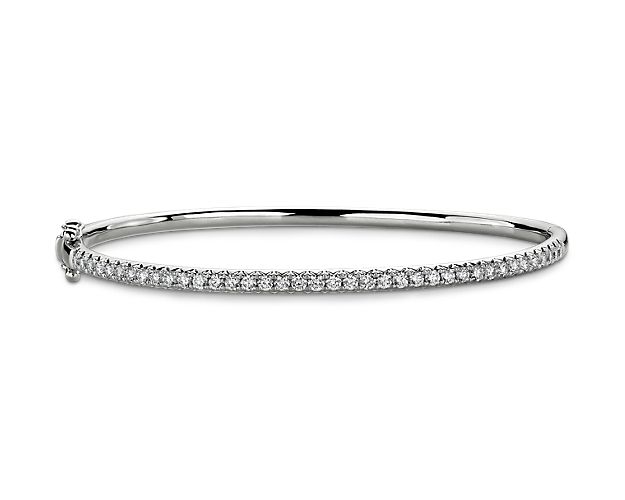This classic bangle bracelet features a dazzling array of diamonds set in bright white gold is sure to make a statement by itself, or in a stack.