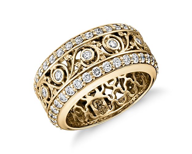 Exquisite decorative detailing makes this significant 18k yellow gold eternity band a true standout. Two rows of pavé-set diamonds frame even more tiny diamonds set in a distinctive swirling leaf design.