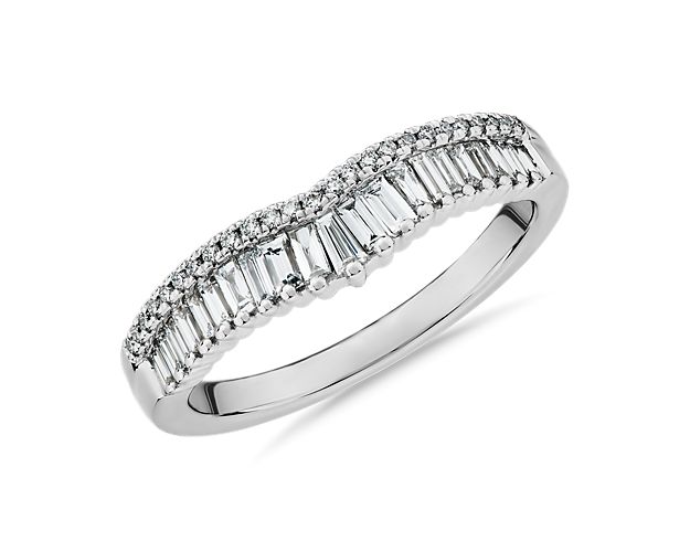 Capture the feeling of love with this Zac Posen wedding ring crafted from 14k white gold, and featuring a crown-like curve to accentuate an engagement ring. It shimmers with 3/8 ct. tw. of diamonds, with north-south baguette diamonds giving it bold sparkle, and pavé-set stones completing the elegant effect.