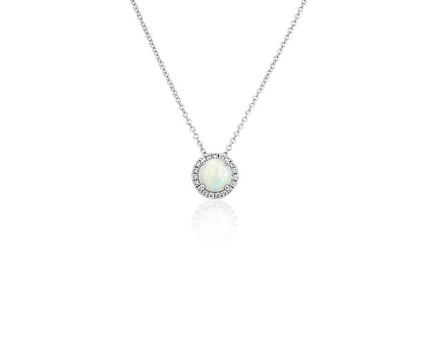 Capture your ray of starlight when layering on this striking 14k white gold pendant necklace. Its perfectly round opal baths in the light of a white diamond halo creating a beautiful interplay of sparkle and color.