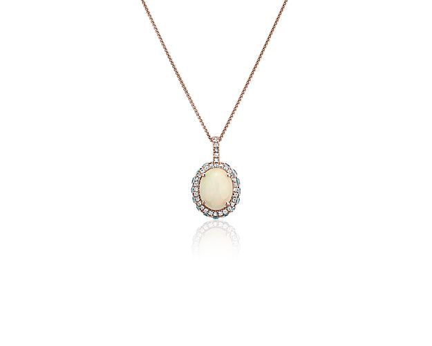Elegant in every way, this opal pendant features a single opal framed by a double halo of blue and white topaz stones set in 14k rose gold.