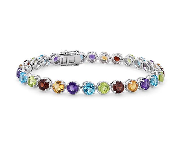 A richly hued array of round-cut blue topaz, amethyst peridot, citrine and garnet is crafted in sterling silver in a flexible single line design.