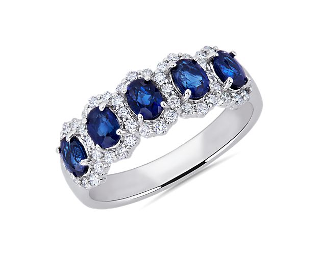 This stunning anniversary band is set with five brilliantly blue oval-cut sapphires, each surrounded by a shimmering diamond halo. Featuring 14k white gold design, it promises a cooly lustrous look that lasts.