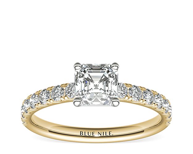 Demure and sparkling, this diamond engagement ring features round diamonds pavé-set in 18k yellow gold to complement your choice of diamond.